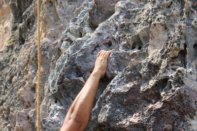 hand hanging on rock face